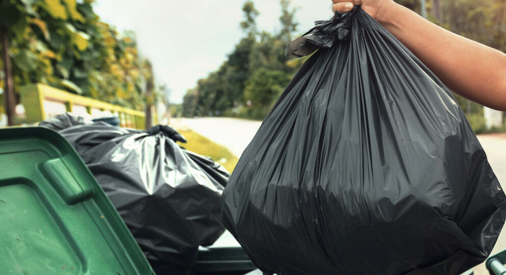 woman hand holding garbage in black bag for cleaning in to trash